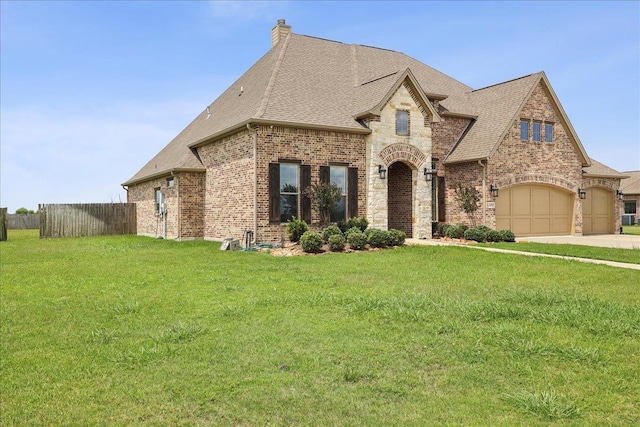 14990 Michelle Ln, Beaumont, TX 77713 - french country inspired facade featuring brick siding, a shingled roof, driveway, and a chimney
