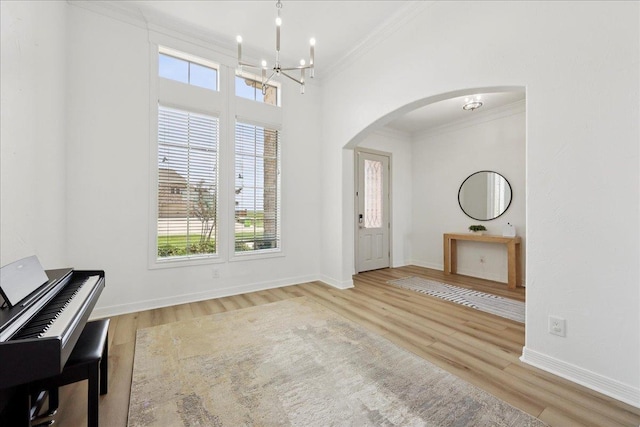 14990 Michelle Ln, Beaumont, TX 77713 - foyer featuring arched walkways, ornamental molding, healthy amount of natural light, a chandelier, and wood finished floors