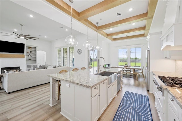 14990 Michelle Ln, Beaumont, TX 77713 - kitchen featuring stainless steel appliances, ceiling fan, white cabinetry, a sink, and beamed ceiling