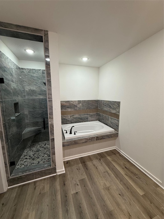 bathroom featuring hardwood / wood-style flooring and separate shower and tub