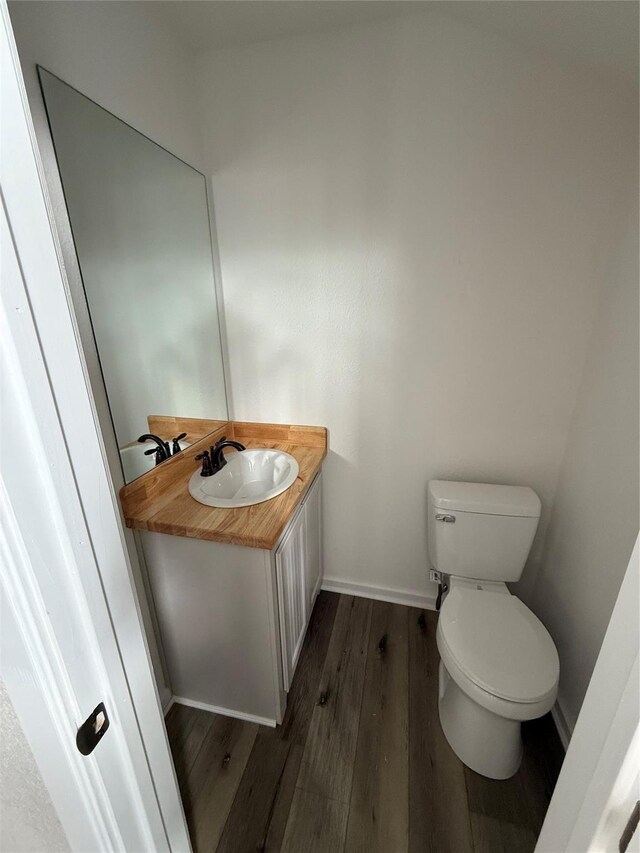 bathroom with vanity, wood-type flooring, and toilet