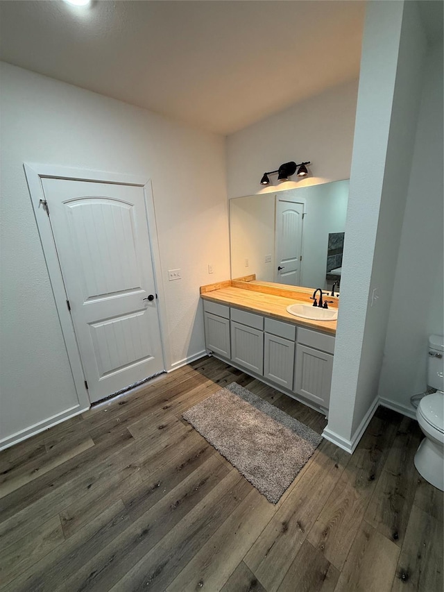 bathroom featuring vanity, hardwood / wood-style flooring, and toilet