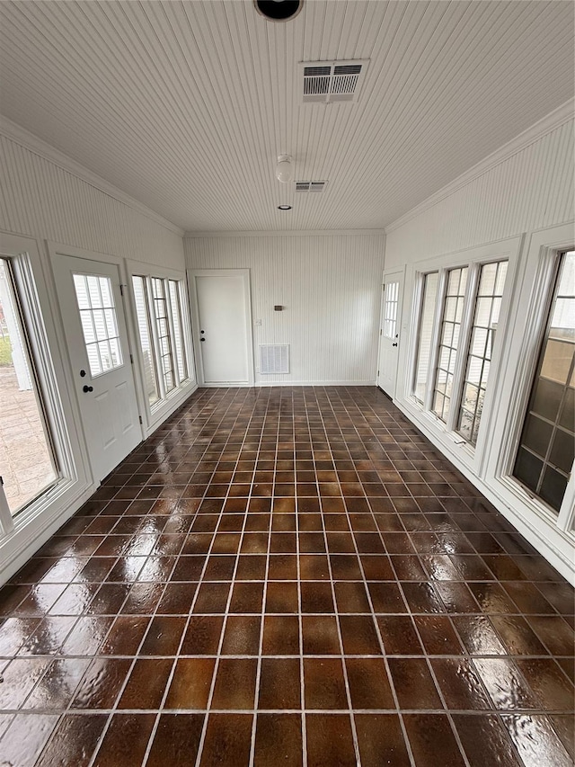 unfurnished living room with plenty of natural light and dark tile patterned flooring