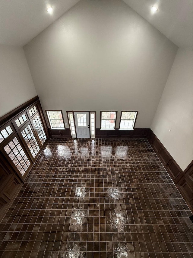 unfurnished living room with high vaulted ceiling