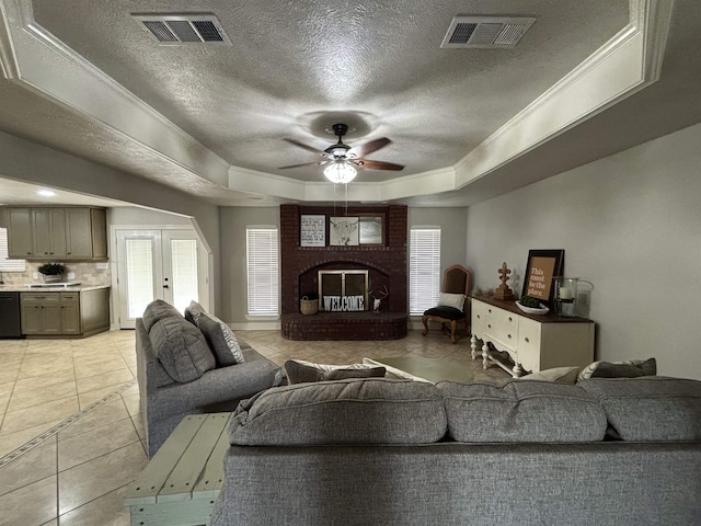 living room with french doors, ornamental molding, a raised ceiling, ceiling fan, and a healthy amount of sunlight