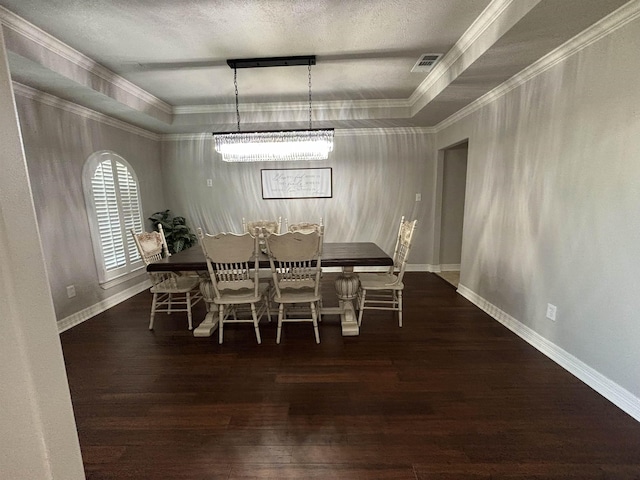 dining space featuring a raised ceiling, a chandelier, a textured ceiling, and ornamental molding