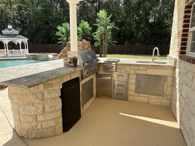 view of patio / terrace with sink, a gazebo, area for grilling, a swimming pool with hot tub, and a grill