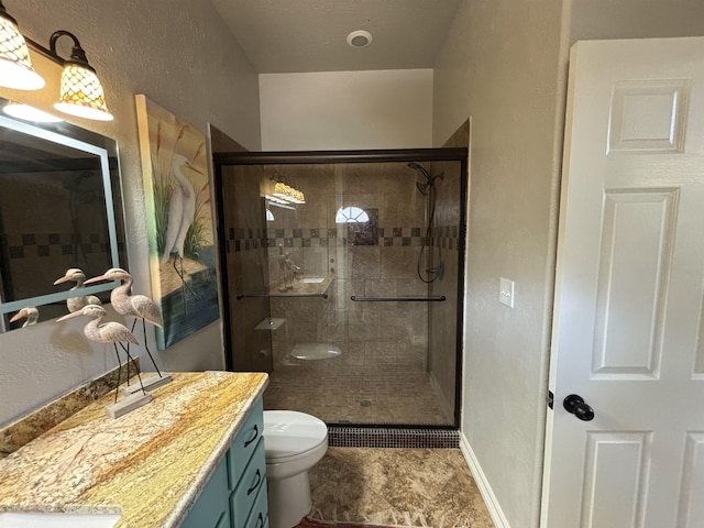 bathroom featuring vanity, toilet, and an enclosed shower