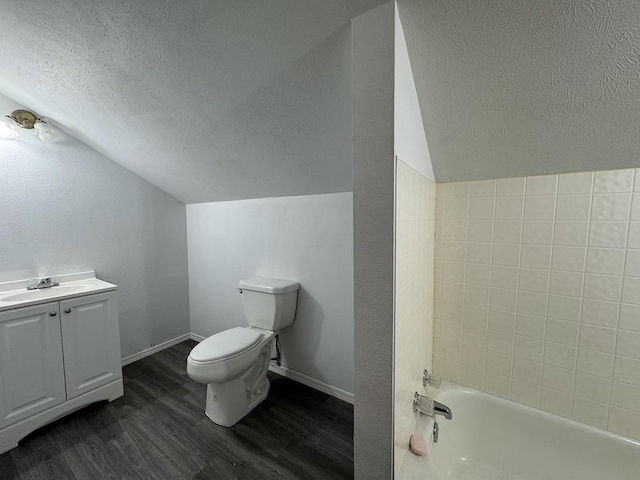 bathroom featuring hardwood / wood-style floors, vanity, vaulted ceiling, toilet, and a textured ceiling