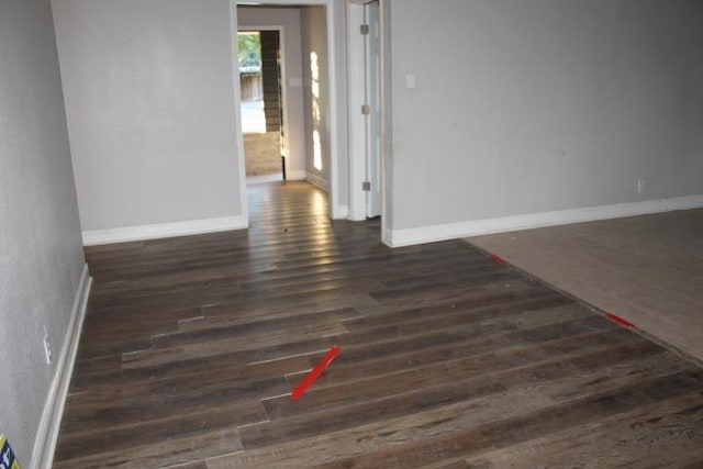 unfurnished room with dark wood-type flooring