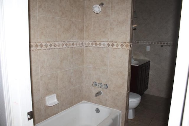 full bathroom with tile patterned floors, vanity, toilet, and tiled shower / bath combo