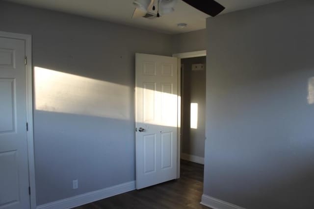 unfurnished bedroom with ceiling fan and dark hardwood / wood-style floors