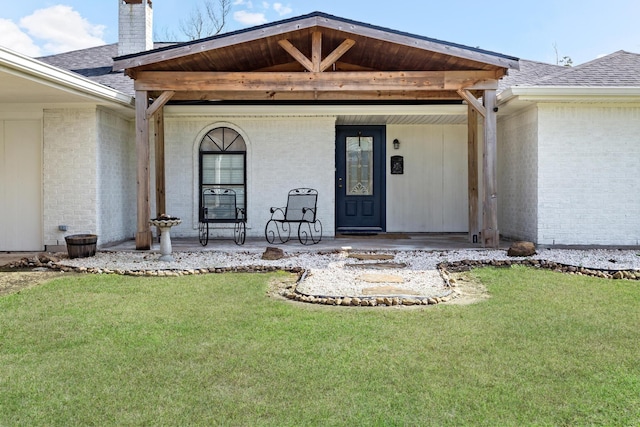 property entrance with a yard and covered porch