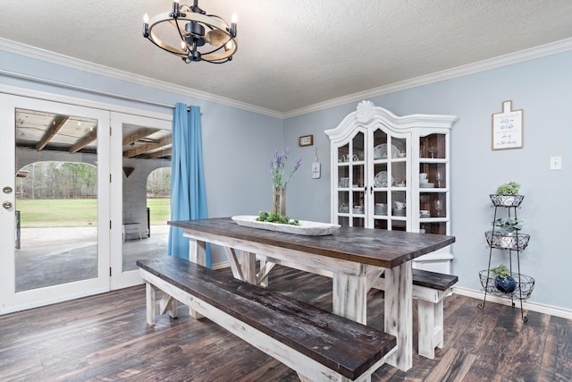 dining space featuring dark hardwood / wood-style flooring, a notable chandelier, crown molding, and a textured ceiling