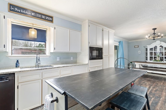 kitchen with white cabinetry, decorative light fixtures, sink, and black appliances