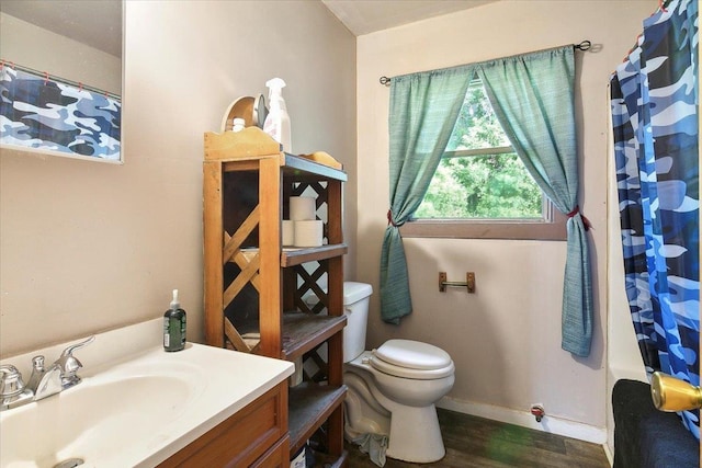 bathroom featuring hardwood / wood-style floors, vanity, toilet, and curtained shower