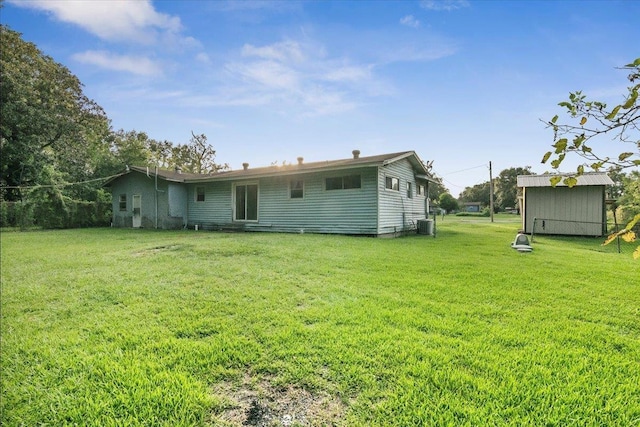 rear view of house featuring a yard and central AC unit