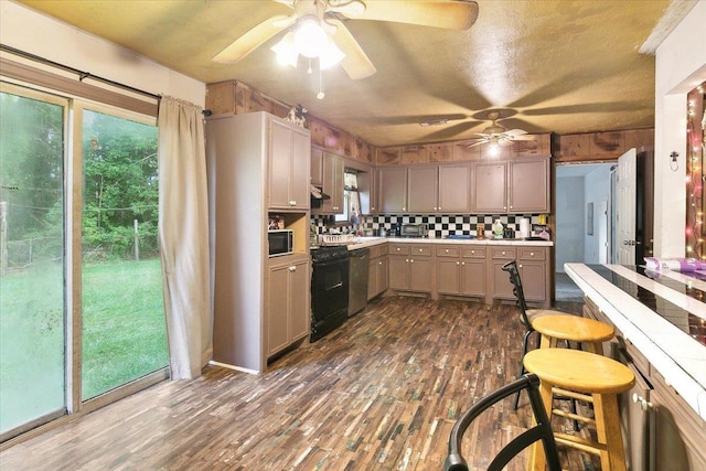 kitchen with black stove, dark hardwood / wood-style flooring, tasteful backsplash, and a textured ceiling