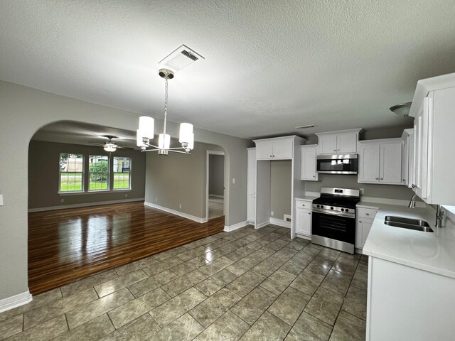 512 N Inwood Dr, Bridge City, TX 77611 - kitchen featuring arched walkways, baseboards, appliances with stainless steel finishes, and visible vents