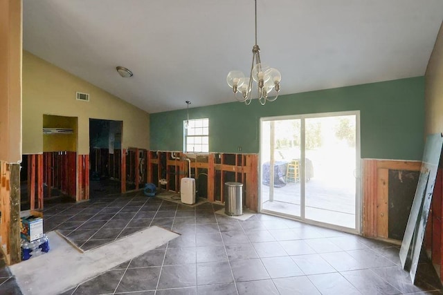 miscellaneous room with dark tile patterned flooring, a notable chandelier, and vaulted ceiling