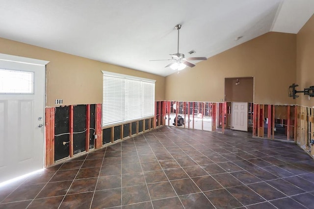 interior space featuring dark tile patterned floors, ceiling fan, and lofted ceiling