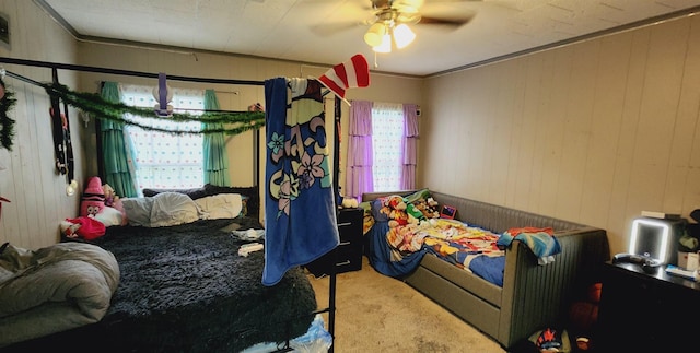 carpeted bedroom with crown molding, ceiling fan, and wood walls