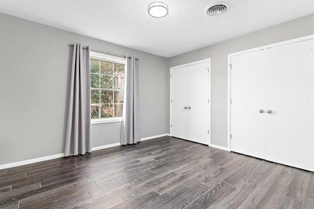 unfurnished bedroom featuring dark hardwood / wood-style flooring