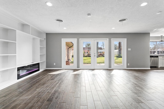 unfurnished living room featuring dark wood-type flooring, sink, a textured ceiling, and french doors