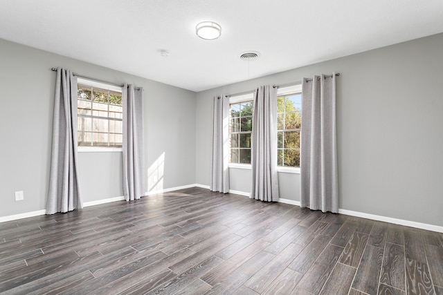 spare room featuring dark hardwood / wood-style floors and a wealth of natural light