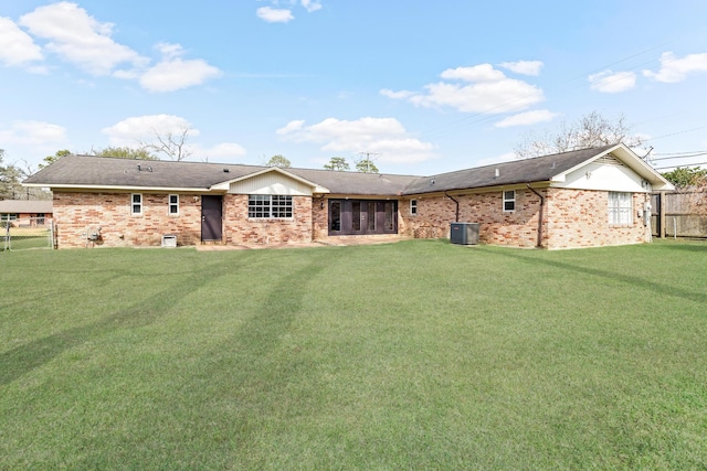 back of house featuring a lawn and central air condition unit