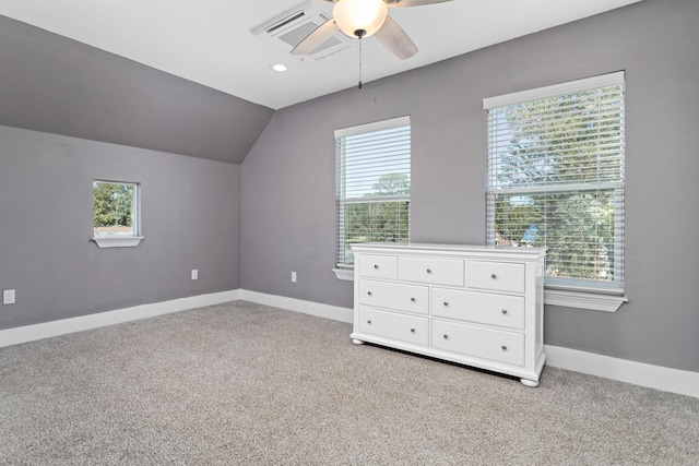 unfurnished bedroom with ceiling fan, light colored carpet, lofted ceiling, and multiple windows