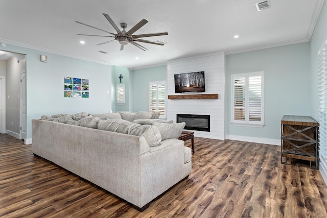 living room with a fireplace, dark hardwood / wood-style flooring, ceiling fan, and crown molding