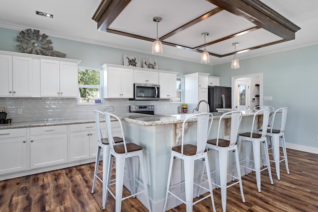 kitchen featuring a center island, hanging light fixtures, decorative backsplash, white cabinetry, and stainless steel appliances