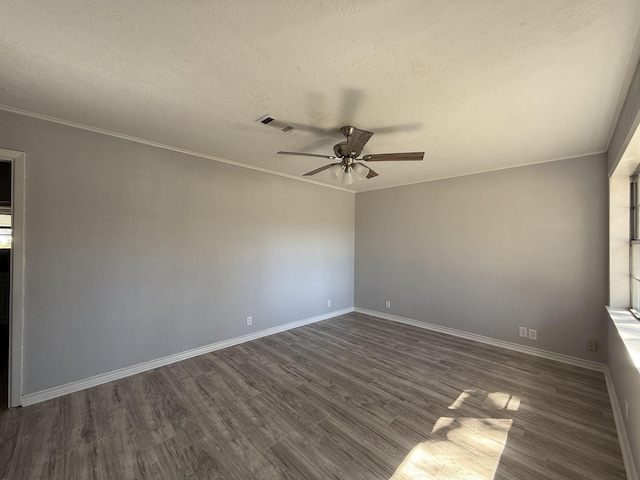 unfurnished room with baseboards, visible vents, a ceiling fan, ornamental molding, and dark wood-type flooring