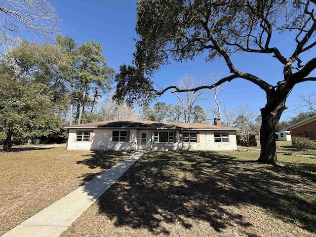 single story home featuring a front yard and a chimney