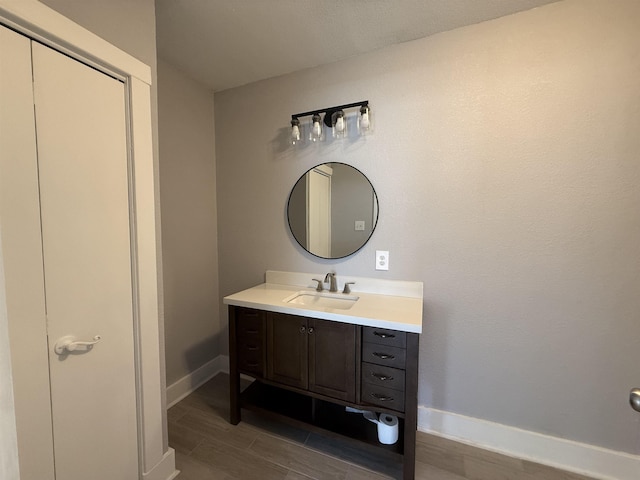 bathroom featuring wood tiled floor, vanity, and baseboards