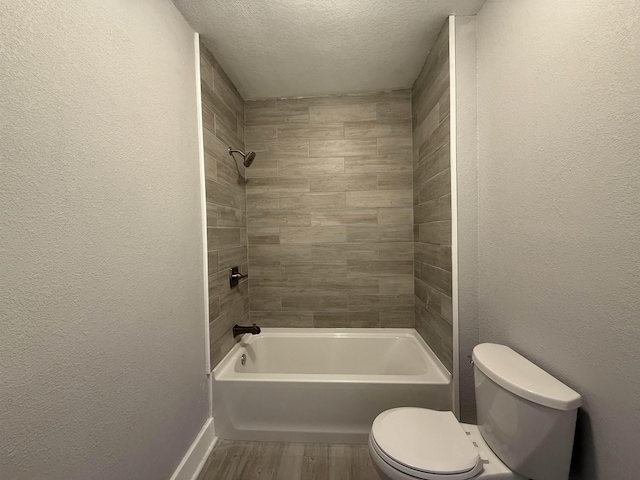 full bathroom featuring a textured ceiling, a textured wall, wood finished floors, and toilet