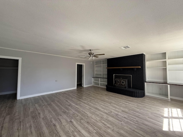 unfurnished living room featuring a textured ceiling, a fireplace, and wood finished floors