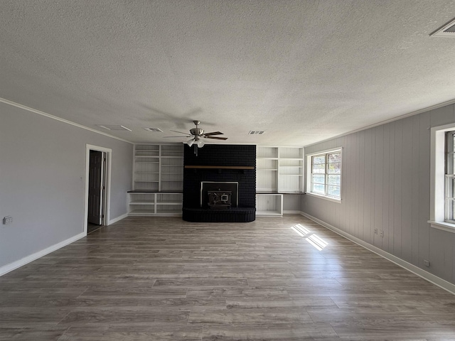 unfurnished living room featuring a textured ceiling, visible vents, and wood finished floors
