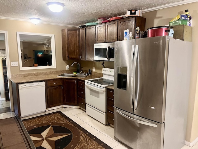 7521 Puntes Ln, Silsbee, TX 77659 - kitchen with light tile patterned flooring, a sink, dark brown cabinetry, and appliances with stainless steel finishes