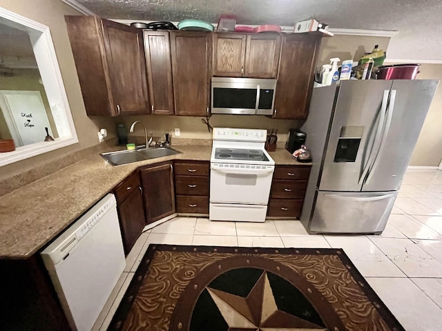7521 Puntes Ln, Silsbee, TX 77659 - kitchen featuring dark brown cabinetry, a sink, stainless steel appliances, and light tile patterned floors