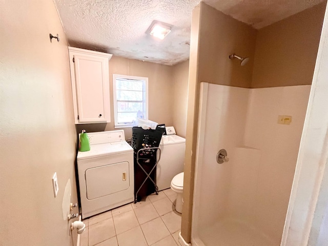 7521 Puntes Ln, Silsbee, TX 77659 - clothes washing area with washing machine and clothes dryer, a textured ceiling, and light tile patterned floors