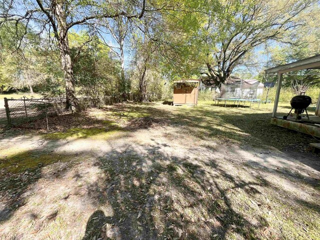 7521 Puntes Ln, Silsbee, TX 77659 - view of yard with an outbuilding, fence, a trampoline, and a shed