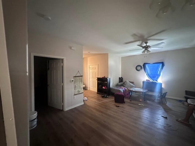 living room featuring ceiling fan and dark hardwood / wood-style floors