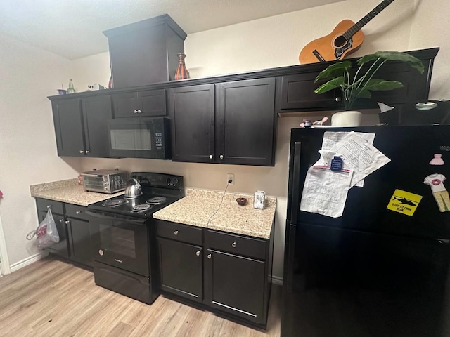 kitchen featuring light wood-type flooring and black appliances