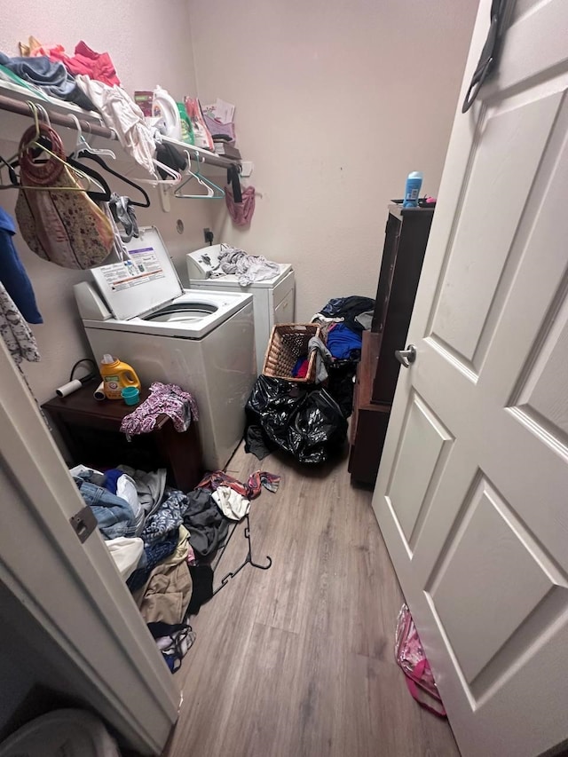 laundry area with washer and dryer and light wood-type flooring