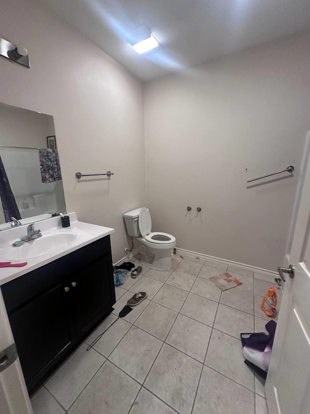 bathroom with toilet, vanity, and tile patterned floors