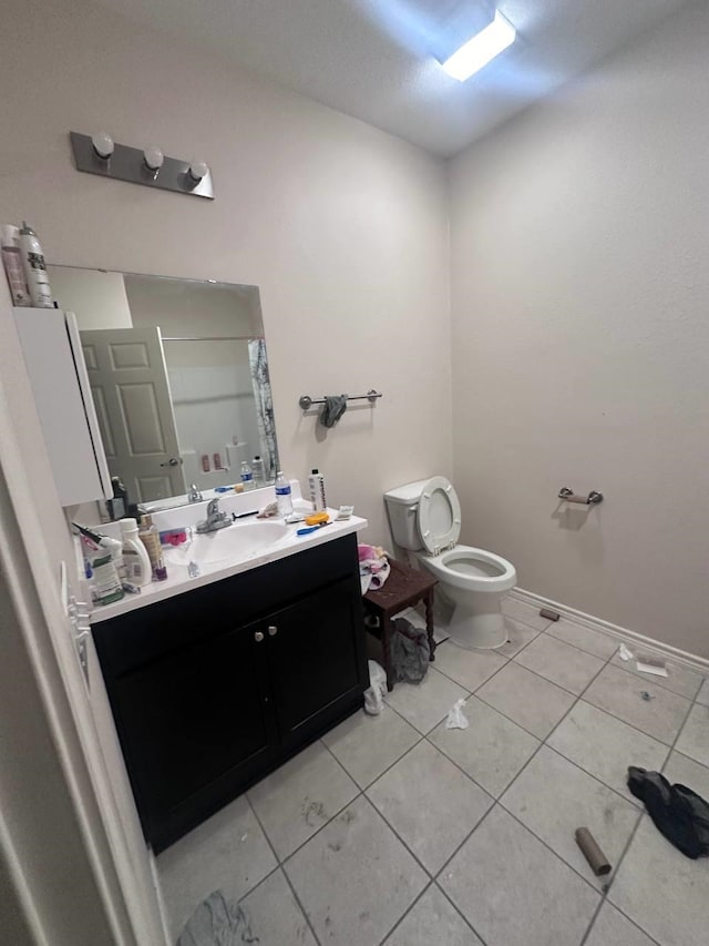 bathroom featuring tile patterned flooring, vanity, toilet, and walk in shower