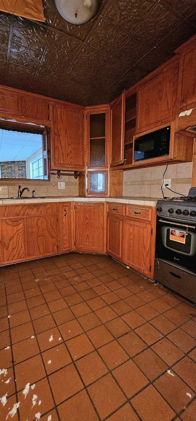 kitchen featuring sink, decorative backsplash, and range with gas stovetop