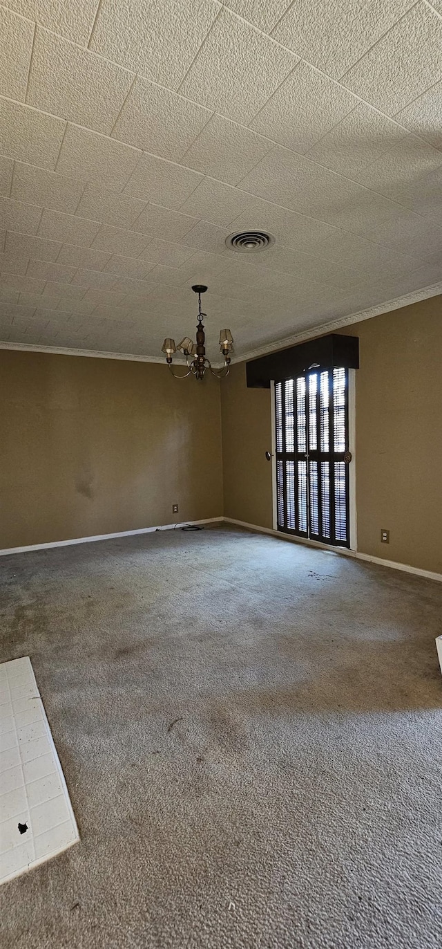 carpeted spare room with an inviting chandelier and ornamental molding